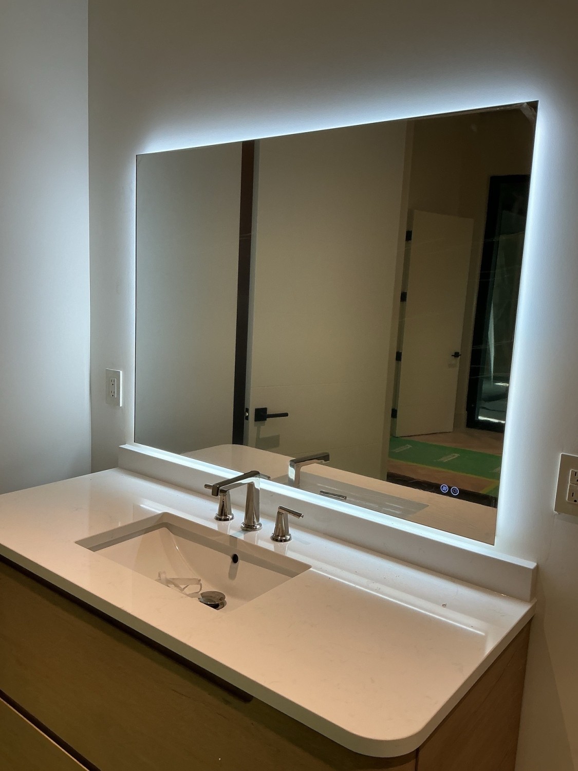 Wide backlit bathroom mirror installation